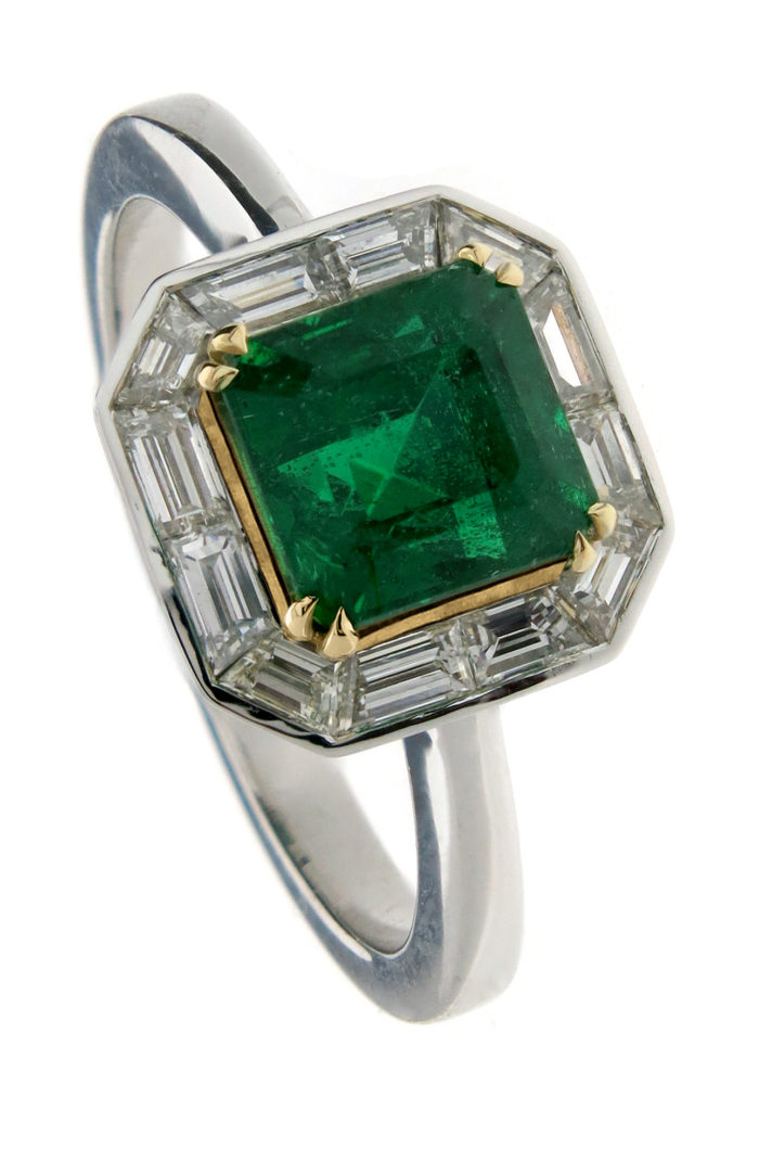 Green emerald set in custom cut baguette halo in yellow and white gold 18k.