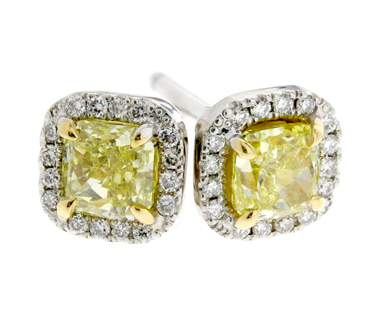 Matching yellow cushion diamonds set in yelow gold with a white diamond halo