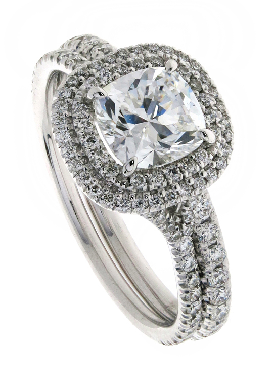 cushion cut diamond set in a double pave halo pictured with heavy diamond pave wedding ring